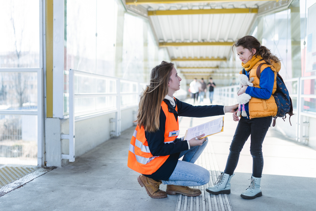 Volunteer Helping Ukrainian Refugee Child at Train Station.